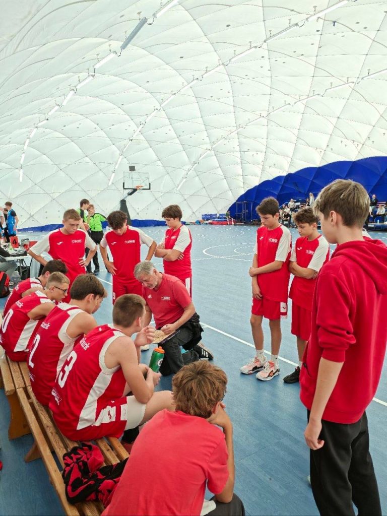 Tým BA Nymburk U15 během porady na lavičce v utkání v Pardubicích.